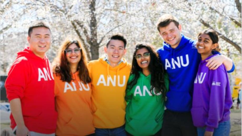 Students wearing ANU sweaters and stand in a row