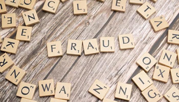 Scrabble-style letter tiles arranged on a wooden surface. In the center, the word 